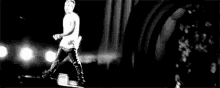 a black and white photo of a man standing on a stage .