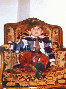 a young boy is sitting in a chair with his feet up