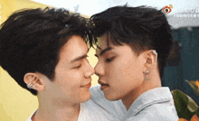 two young men are touching their noses and looking at each other .