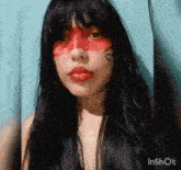 a woman with red paint on her face has the word inshot at the bottom of the image