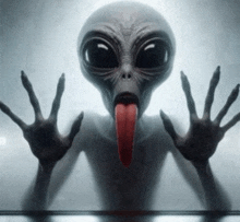 a gray alien sticking out its tongue and making a funny face