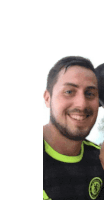 a man with a beard is smiling for the camera and wearing a black and yellow shirt .