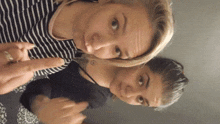 two women are posing for a picture and one has a smiley face tattoo