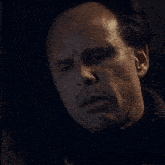a close up of a man 's face with a candle in the background