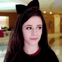 a woman wearing a black headband with a bow on it