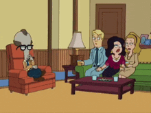 a group of people are sitting in a living room with a man in a chair