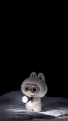 a stuffed animal is holding a flashlight in its hands