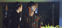 two young men are standing next to each other in a dark room .