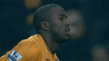 a man wearing a yellow jersey with the word wolves on the front