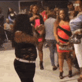 a woman is dancing in front of a crowd of people at a party .