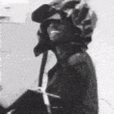 a black and white photo of a man wearing a helmet and sunglasses .