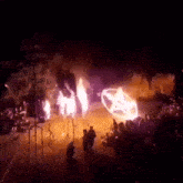 a group of people watching a car on fire