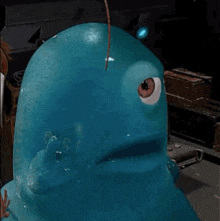 a close up of a blue cartoon character with a single eye