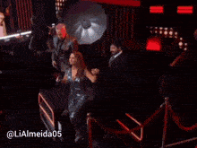 a woman singing into a microphone next to a man in a suit with the hashtag lialmeida05