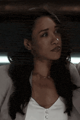 a close up of a woman 's face wearing a white shirt and a jacket .