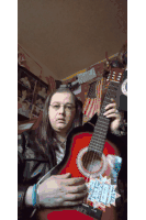 a man is holding a red guitar with a sticker on it that says ' texas ' on it