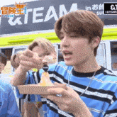 a young man is holding a plate of food in front of a truck that says team