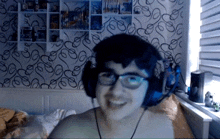 a boy wearing headphones and glasses is smiling