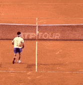 a man is holding a tennis racquet while standing on a tennis court