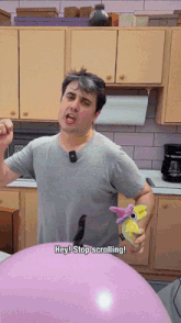 a man in a kitchen holding a stuffed animal with the words hey stop scrolling below him