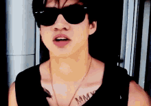 a man wearing sunglasses has a tattoo on his chest that says mm