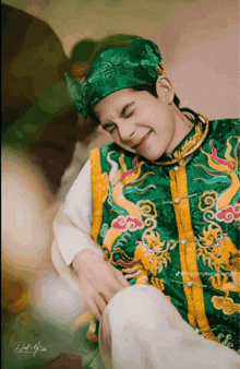 a man wearing a green and yellow costume with dragons and clouds