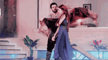 a man is holding a woman in his arms and she is wearing a purple dress
