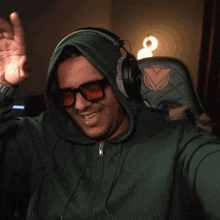 a man wearing headphones and sunglasses is smiling and waving