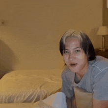 a person sitting on a bed with a lamp on the nightstand