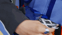 a close up of a person 's hand holding a blue object with the letter x on it
