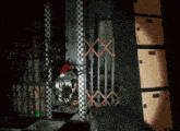 a person is sitting in a cage in a dark room with a checkered floor .