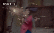 a woman in a pink saree is running through a room .