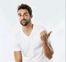 a man with a beard wearing a white t-shirt is pointing at something