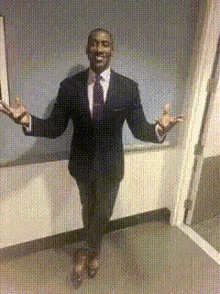 a man in a suit and tie is standing in front of a mirror with his arms outstretched