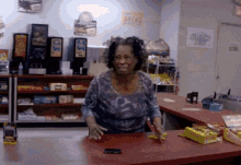 a woman stands at a counter in a store with a sign on the wall that says ' candy '