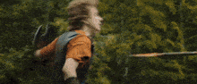 a man and a woman are fighting with swords in the woods .