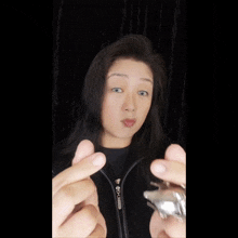 a woman wearing a black jacket with a zipper that says ' givenchy ' on it