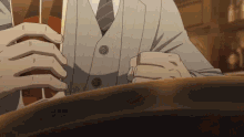 a man in a suit and tie is sitting at a table holding a glass of whiskey