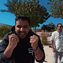 a man wearing a black sweatshirt with the letter u on the front