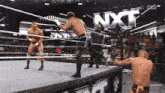 wrestlers in a ring with the nxt logo behind them