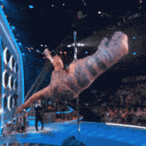 a t-rex is on a pole in front of a crowd of people