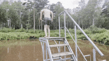 a man stands on a platform overlooking a lake