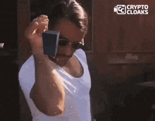 a man wearing sunglasses and a white shirt with the words crypto cloaks in the corner