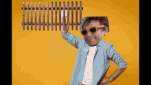 a man wearing sunglasses holds up a wooden fence