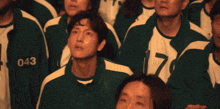 a group of people wearing green and white uniforms with the number 043 on the back