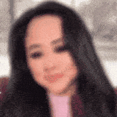 a blurry picture of a woman with long black hair smiling