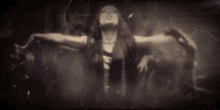 a woman with her arms outstretched is surrounded by other people