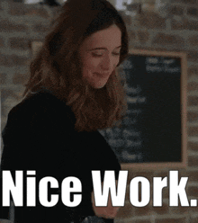 a woman is standing in front of a chalkboard with the words `` nice work '' written on it .