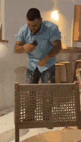 a man in a blue shirt looks at his phone
