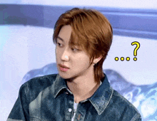 a young man in a denim jacket with a question mark above his head